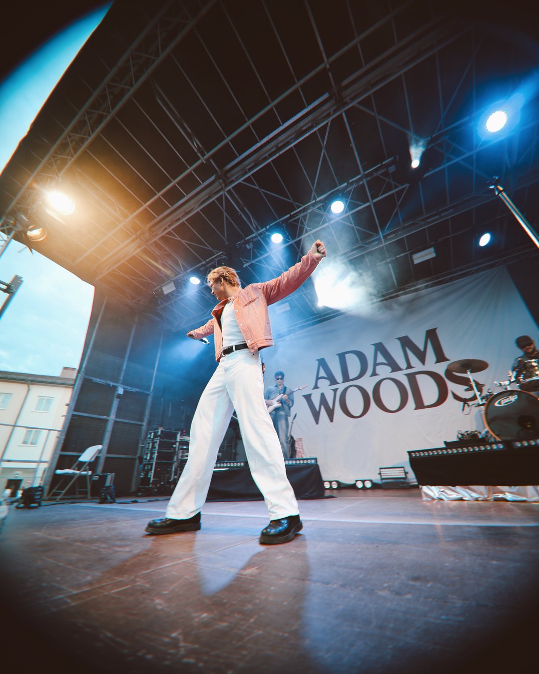 Adam Woods performing on stage in front of an Adam Woods backdrop